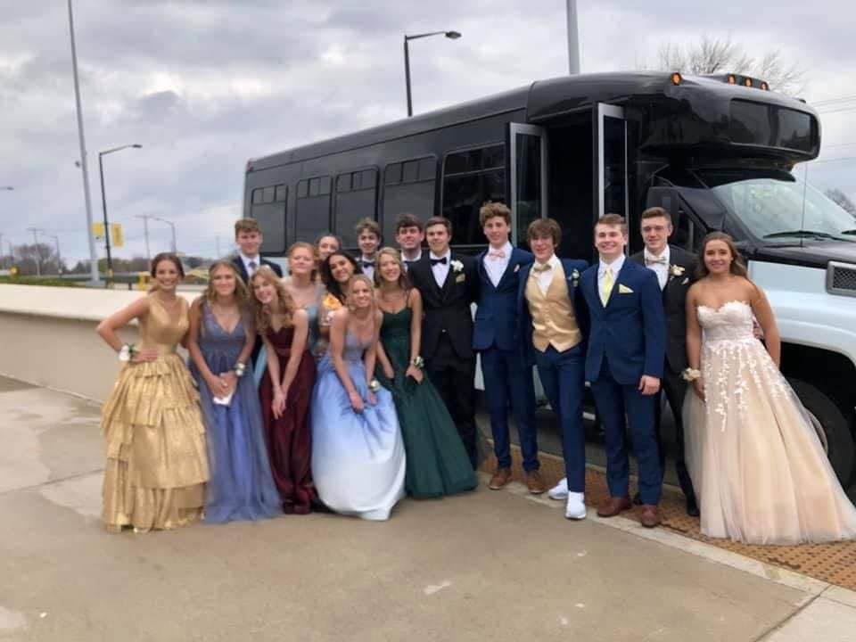 Prom group in front of the open bus door