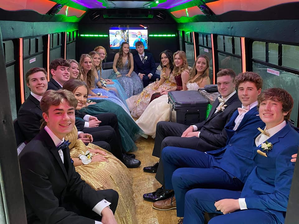 Students dressed for prom with the party bus.